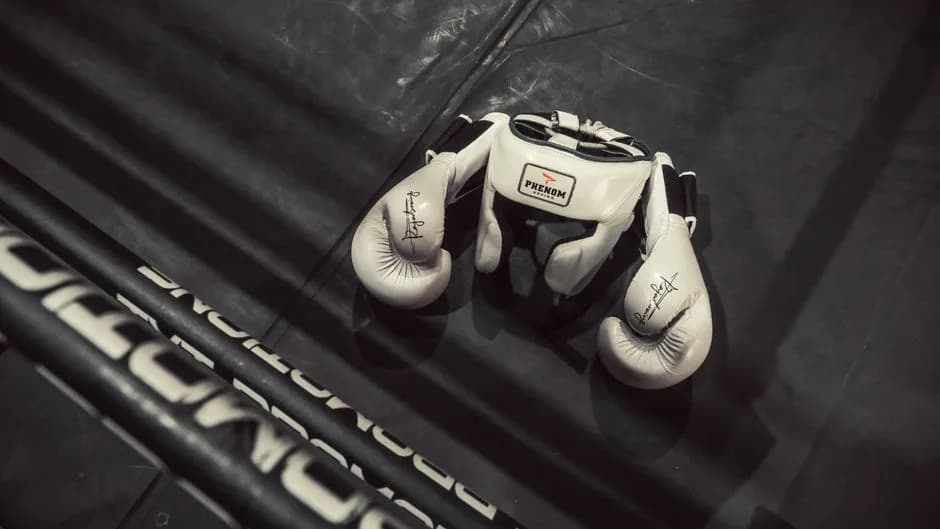 White boxing gloves and headgear on a boxing ring floor