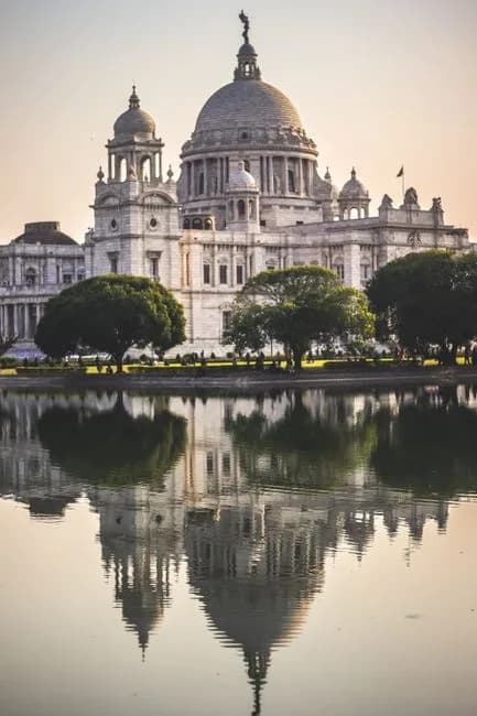 Elegant view of Victoria Memorial reflecting in tranquil water at sunset in Kolkata India