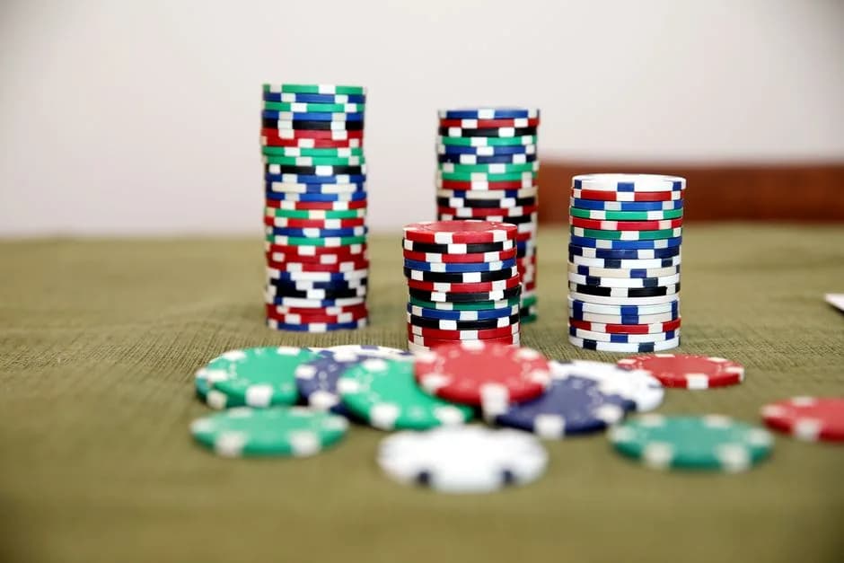 Stacks of colourful poker chips on a green felt table