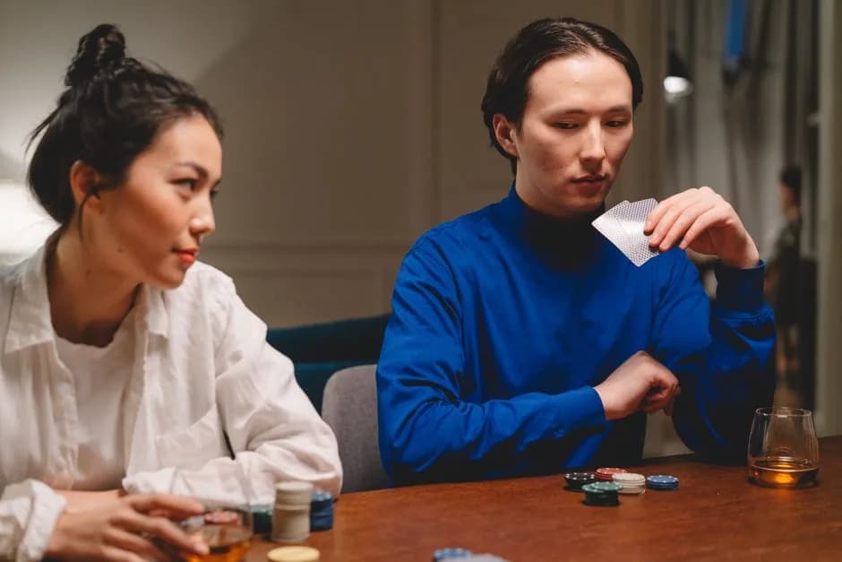 Two people focused on a card game comparing hands