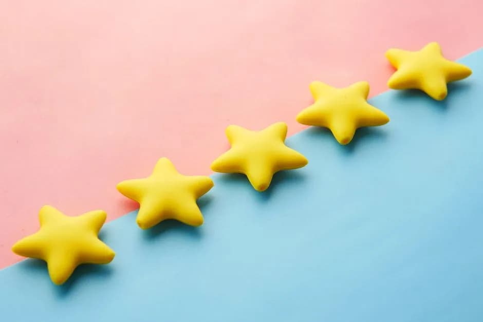 Yellow stars on pink and blue pastel background for a rating concept