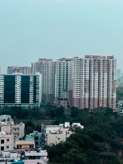 Modern residential buildings in Hyderabad India with lush greenery under blue sky