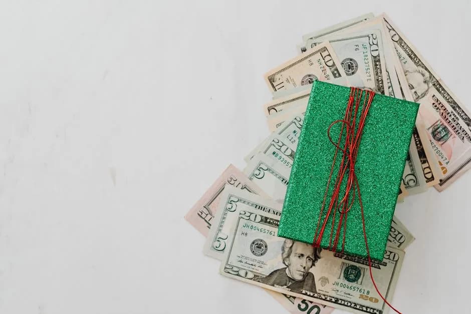 Gift box on a pile of banknotes representing a bonus promotion