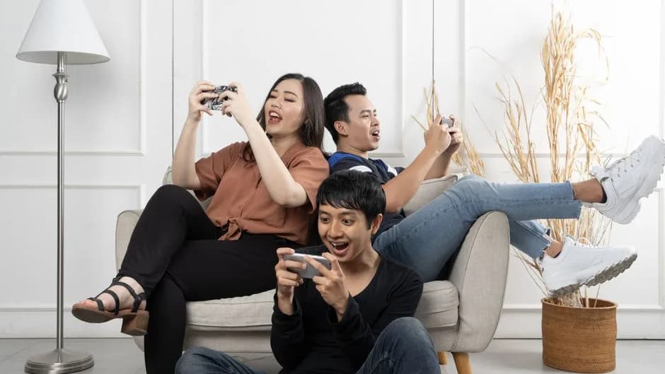 Group of friends playing mobile games together on smartphones