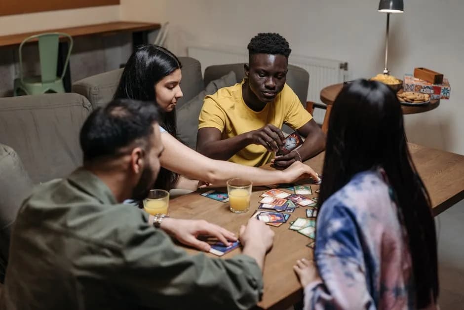 A diverse group of friends playing a card game together indoors, representing teen patti with friends