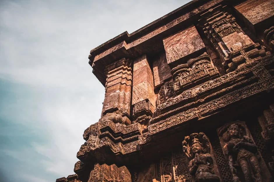 Carved sculptures on the stone walls of Konark Sun Temple Odisha India against cloudy sky