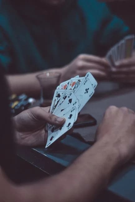 Close-up of hands holding playing cards during a game