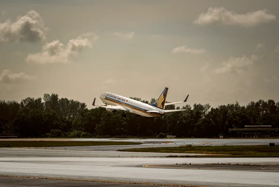 Airplane taking off from runway soaring into a partly cloudy sky