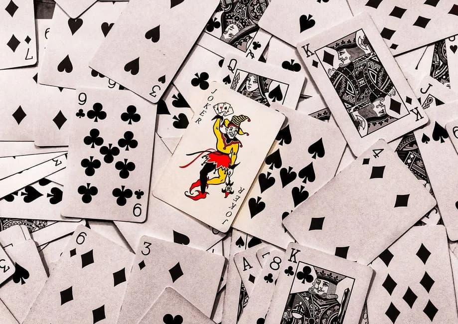 Joker card standing out in a scattered deck of playing cards