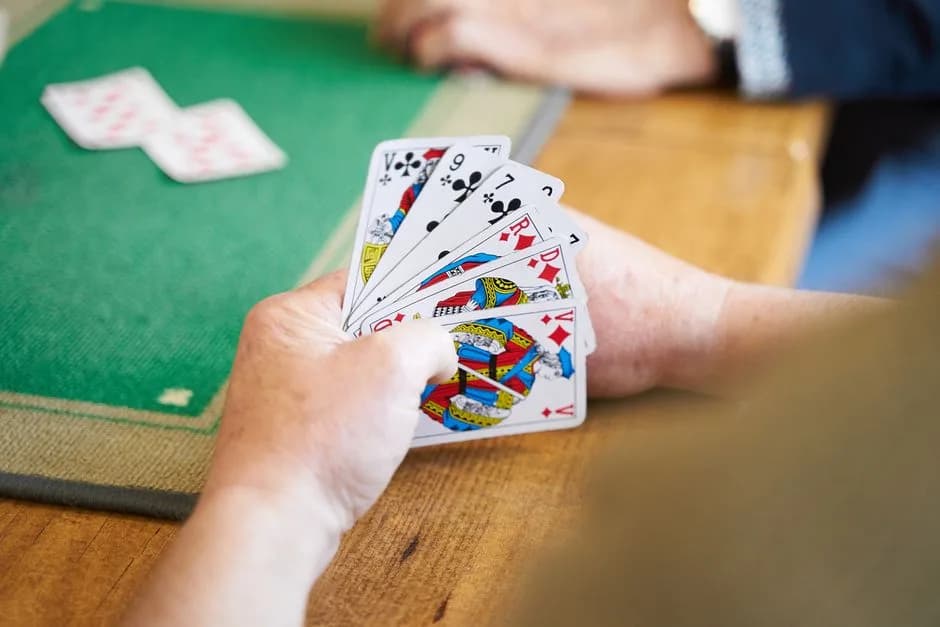 Hands holding playing cards during an indoor card game