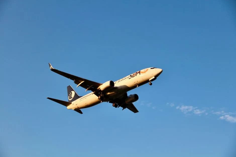 Commercial airplane flying against a clear blue sky during daytime