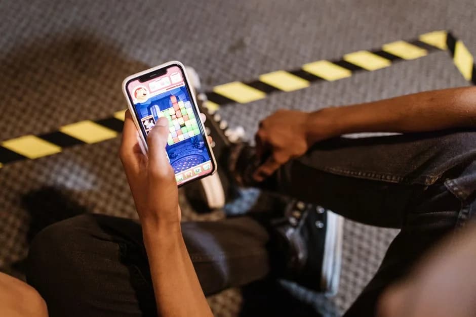 Person playing a mobile game on a smartphone, representing a cash rewards gaming app