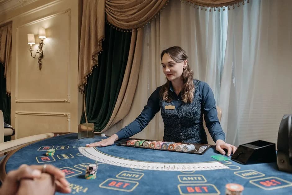 Casino dealer holding playing cards at an elegant gambling table