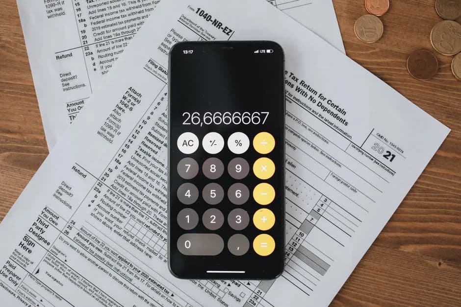 Calculator and tax documents on a wooden surface