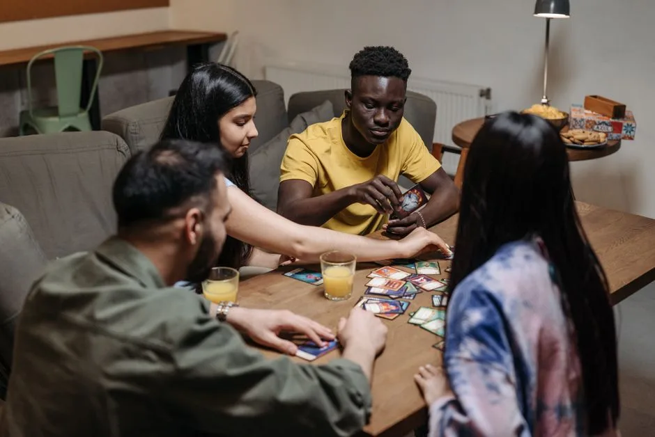 A diverse group of friends playing a card game together indoors
