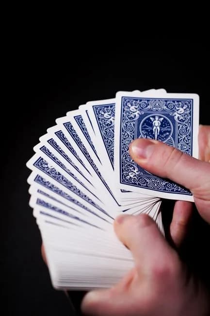 A fanned deck of playing cards held against a dark background