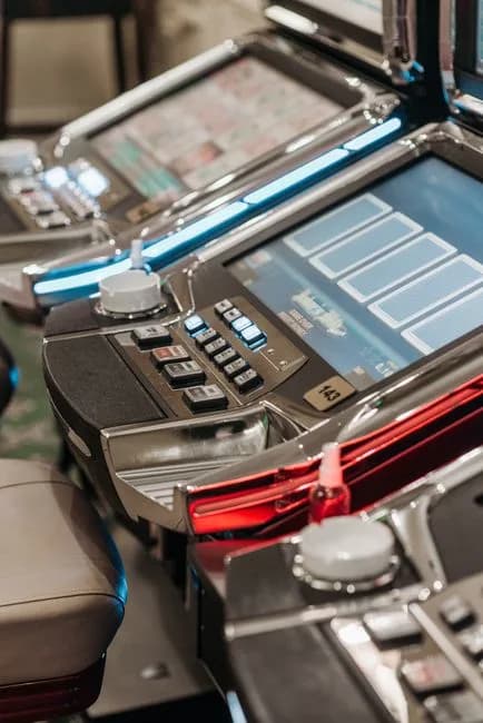 Detailed view of illuminated slot machines in a casino showcasing vibrant screens and controls