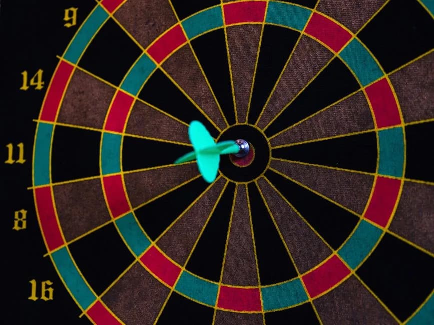 A dart hitting the bullseye on a colorful dartboard, representing a precise target