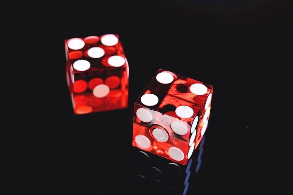 Close-up of two red dice showing 4 and 5 on a shiny black background